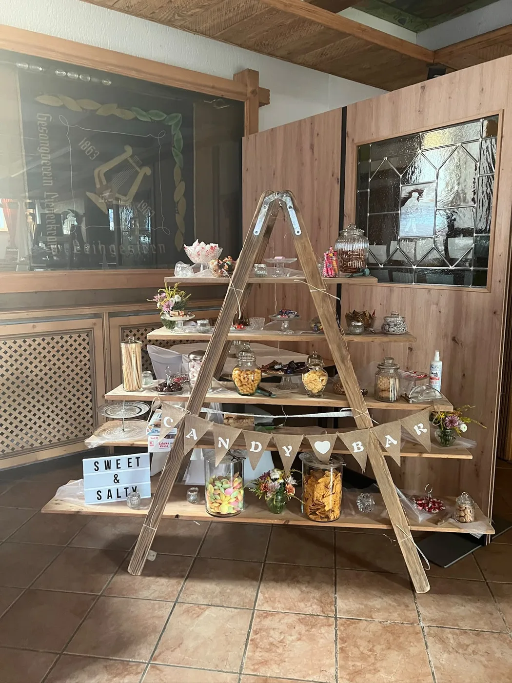 Dekorative Candybar mit Süßigkeiten auf einer Holzleiter