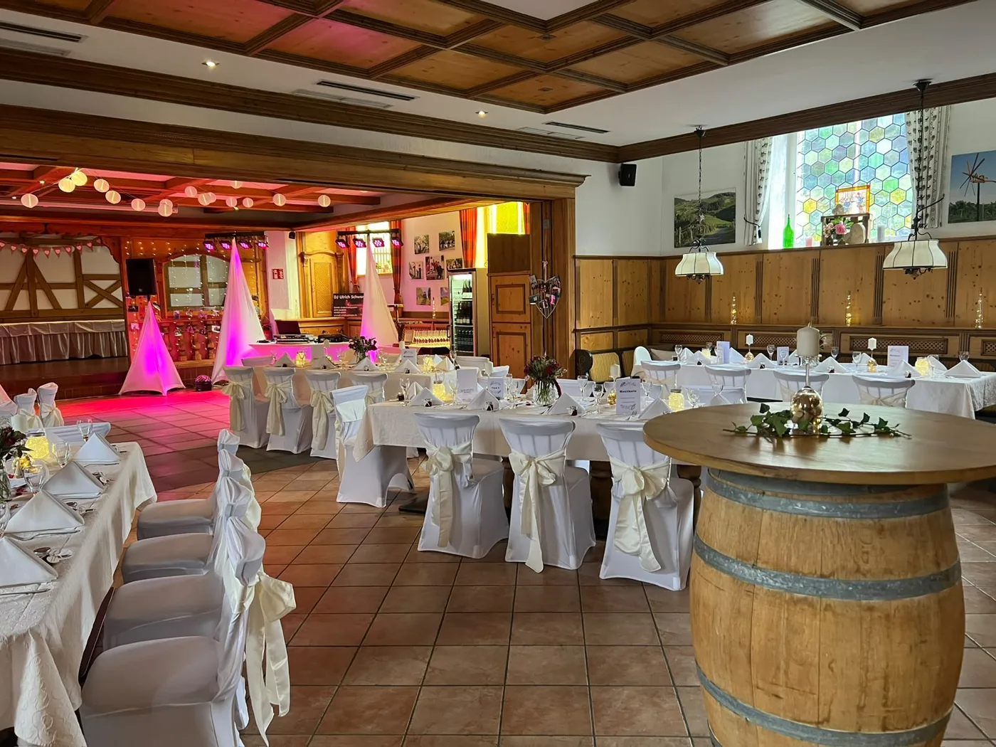 Festlich eingedeckter Hochzeitssaal mit runden Tischen und stimmungsvoller Beleuchtung